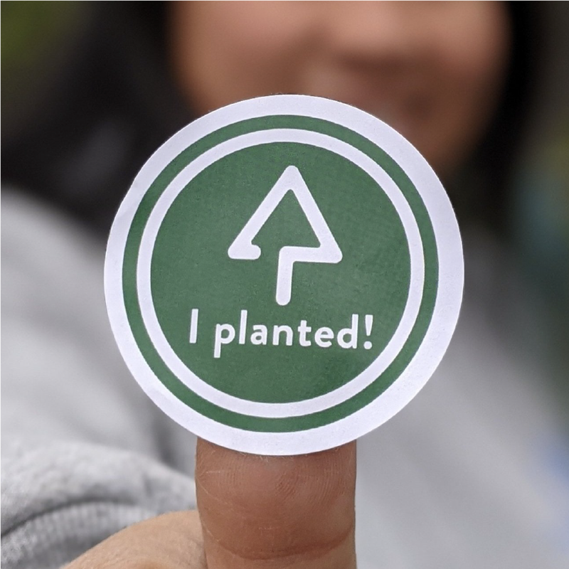 Person holding a Reforest Richmond sticker 