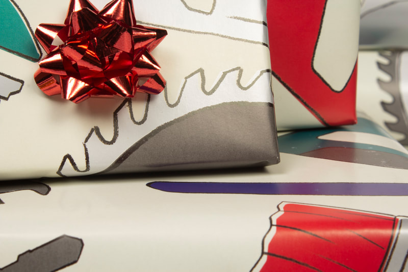 Closeup photo of three boxes wrapped in wrapping paper with tools illustrated on it